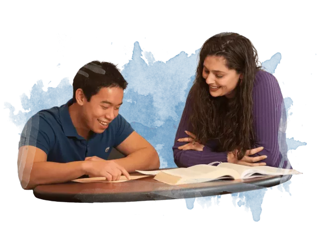 Two people discussing studies while looking at notes